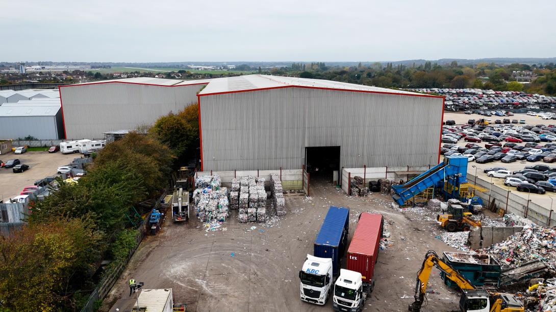 An aerial shot of lorries leaving the James Waste recycling facility in Rochford. Piles of material are being sorted and bales of recycled material are placed against the warehouse.